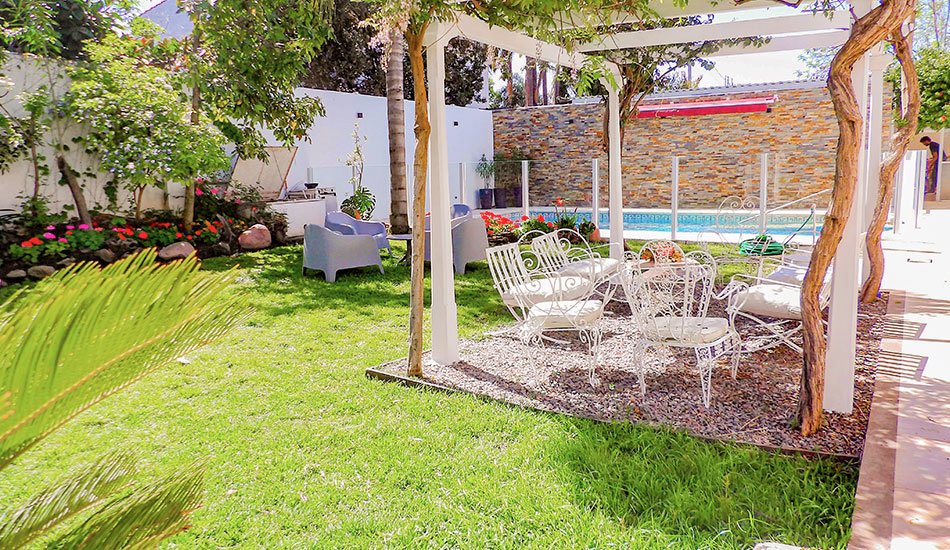 Piscina climatizada de Residencia del Sol con jardín y flores